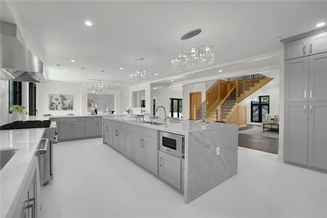 kitchen featuring a chandelier, gray cabinets, built in microwave, open floor plan, and recessed lighting