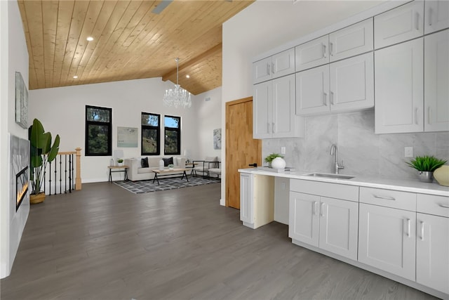 kitchen with a sink, a chandelier, wooden ceiling, light wood-style flooring, and light countertops