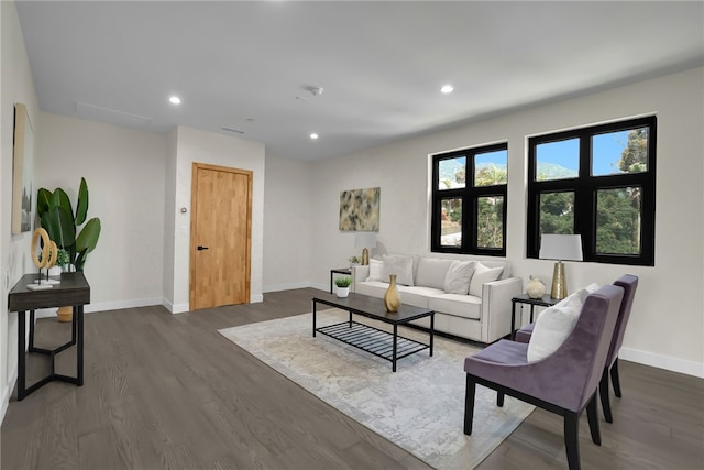 living room featuring baseboards, dark wood finished floors, and recessed lighting