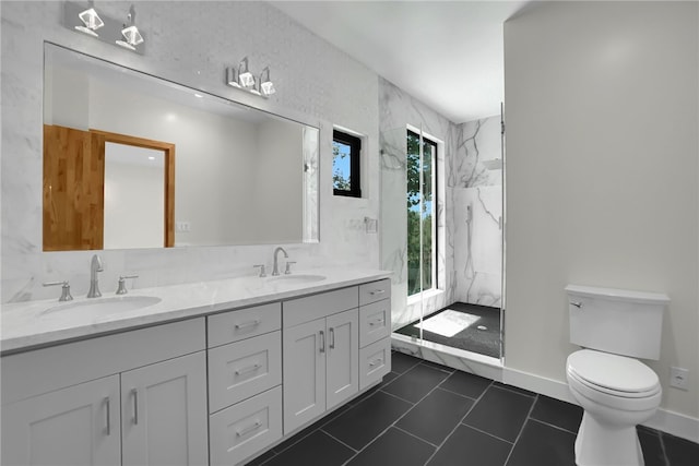 bathroom featuring toilet, double vanity, a marble finish shower, and tile patterned floors