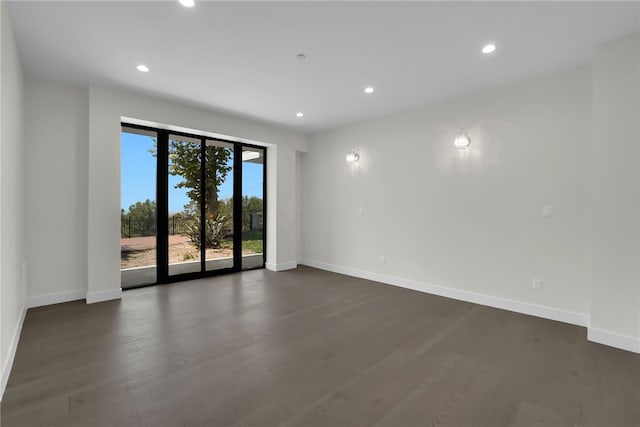 empty room with baseboards, dark wood-style flooring, and recessed lighting