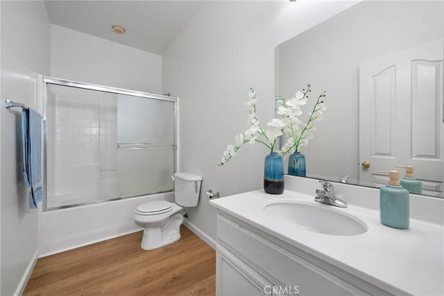 225 Caldera Ln, Hemet, CA 92545 - bathroom featuring vanity, toilet, combined bath / shower with glass door, wood finished floors, and baseboards