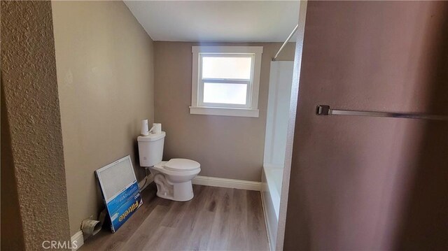 533 S Kaweah Ave, Exeter, CA 93221 - bathroom featuring toilet, wood finished floors, and baseboards