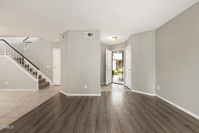 817 Copper Privado, Ontario, CA 91762 - unfurnished living room with wood finished floors, baseboards, stairs, and a textured ceiling