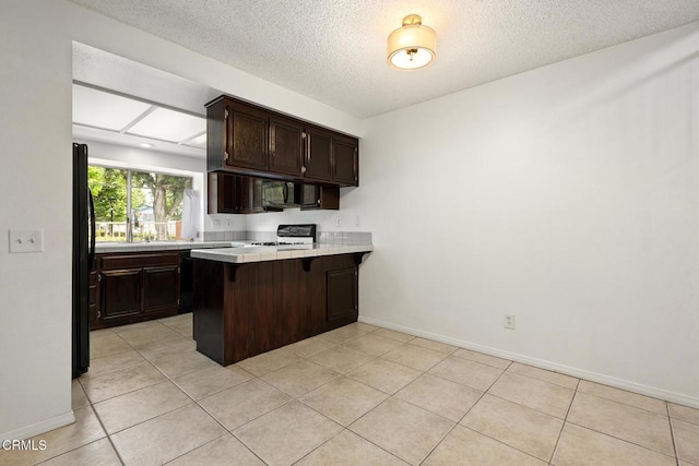 817 Copper Privado, Ontario, CA 91762 - kitchen featuring black appliances, dark brown cabinetry, a peninsula, a textured ceiling, and tile countertops