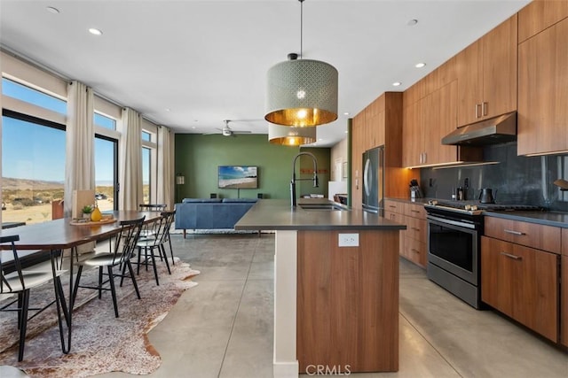 kitchen featuring stainless steel appliances, a sink, finished concrete floors, under cabinet range hood, and recessed lighting