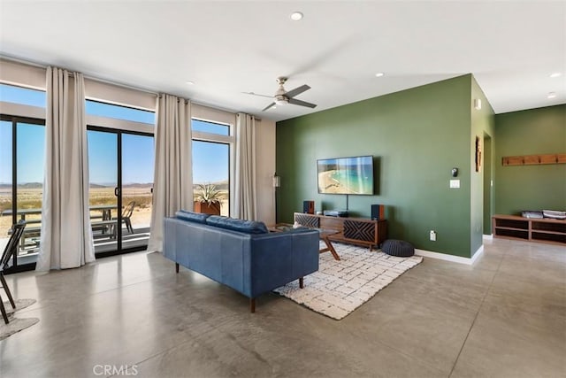 living room featuring concrete flooring, baseboards, a ceiling fan, and recessed lighting