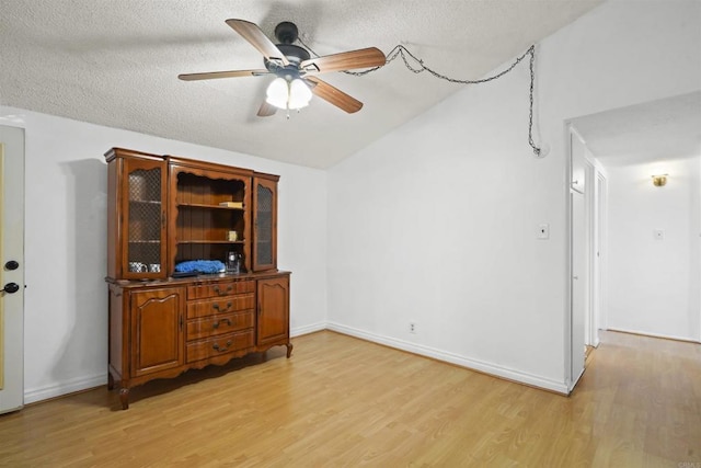 17010 Pocono St, La Puente, CA 91744 - spare room featuring light wood-style floors, ceiling fan, vaulted ceiling, a textured ceiling, and baseboards