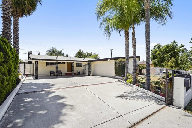 17010 Pocono St, La Puente, CA 91744 - view of front facade with a gate, fence, a garage, and stucco siding