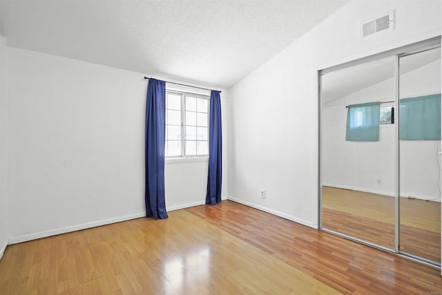 17010 Pocono St, La Puente, CA 91744 - unfurnished bedroom with wood finished floors, a closet, baseboards, a textured ceiling, and lofted ceiling