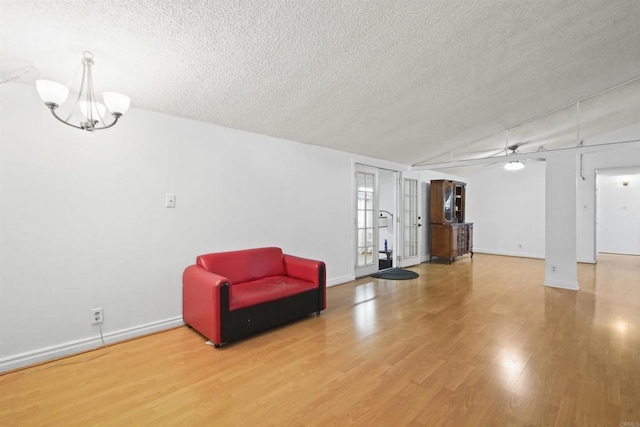 17010 Pocono St, La Puente, CA 91744 - living area with a textured ceiling, wood finished floors, baseboards, a chandelier, and vaulted ceiling