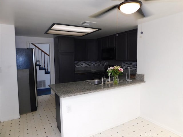 10755 Jasper Ave, Redlands, CA 92374 - kitchen featuring black microwave, freestanding refrigerator, light floors, a peninsula, and tasteful backsplash