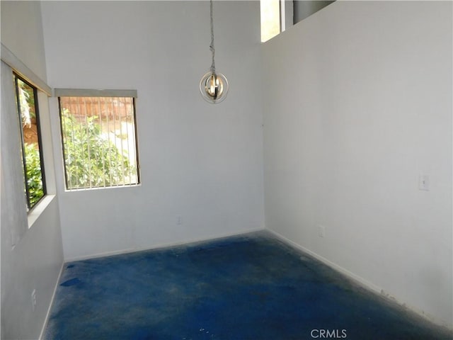 10755 Jasper Ave, Redlands, CA 92374 - unfurnished room with healthy amount of natural light, a high ceiling, a chandelier, and baseboards