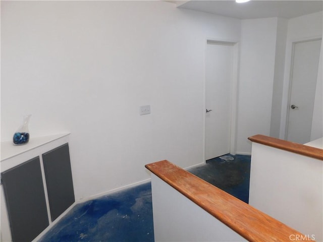 10755 Jasper Ave, Redlands, CA 92374 - hallway featuring unfinished concrete flooring and an upstairs landing