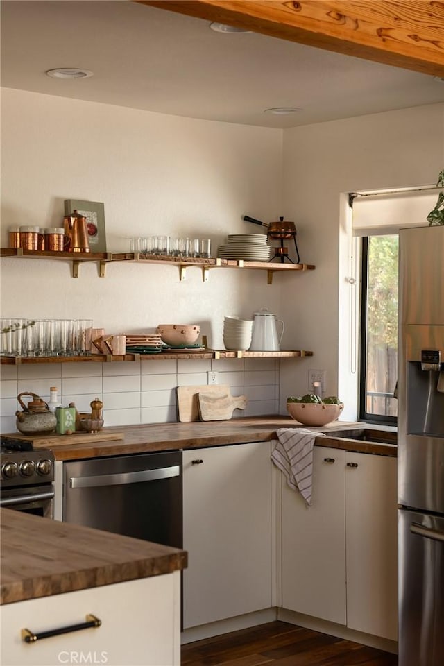 kitchen featuring stainless steel appliances, butcher block counters, open shelves, white cabinetry, and dark wood-style flooring