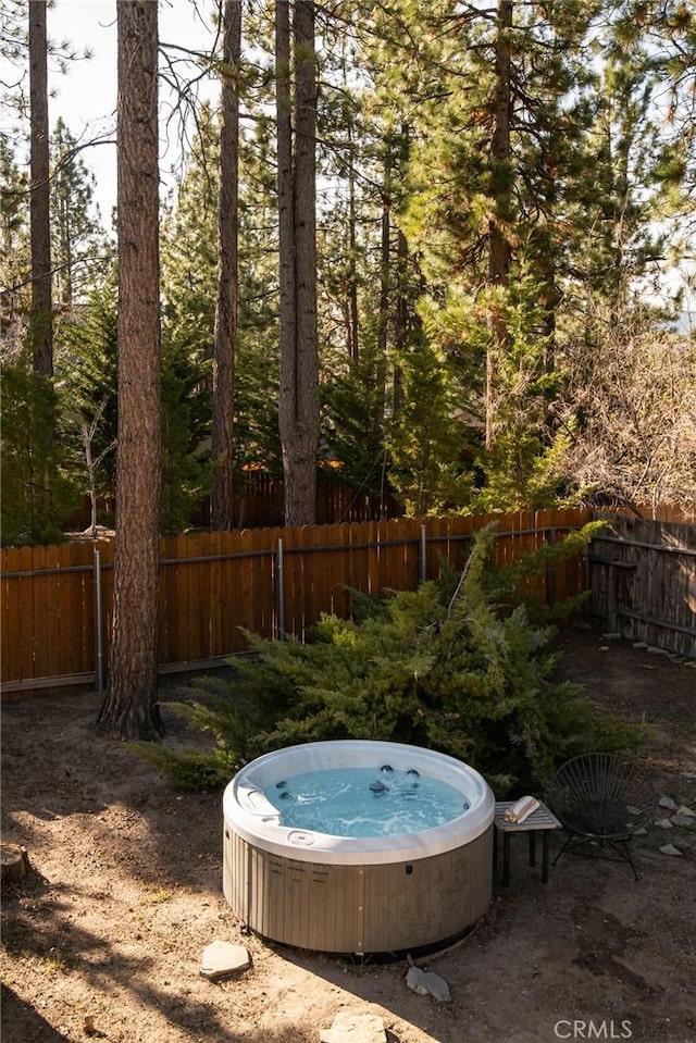 view of yard featuring fence and a hot tub