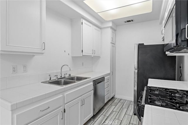 21848 S Vermont Ave Unit 6, Torrance, CA 90502 - kitchen with stainless steel dishwasher, white cabinetry, gas range, and tile countertops
