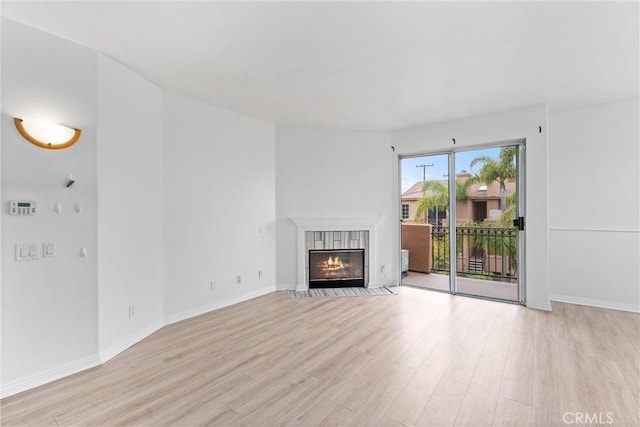 21848 S Vermont Ave Unit 6, Torrance, CA 90502 - unfurnished living room featuring light wood finished floors and a tiled fireplace