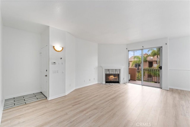 21848 S Vermont Ave Unit 6, Torrance, CA 90502 - unfurnished living room featuring light wood finished floors and a tile fireplace