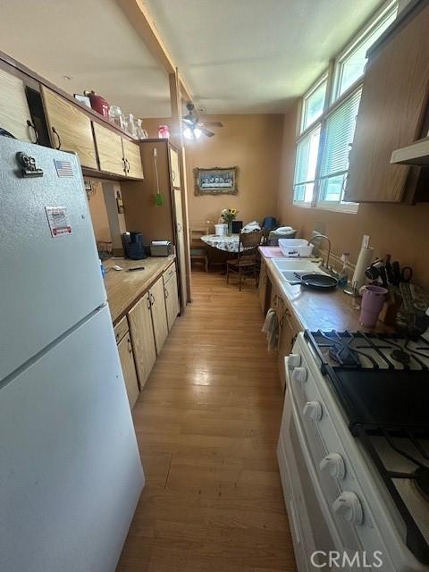 1815 W 9th St, Pomona, CA 91766 - kitchen featuring white appliances, light wood-style floors, a sink, ceiling fan, and light countertops