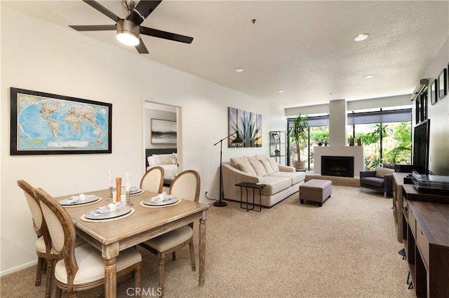 270 Cagney Ln Unit 215, Newport Beach, CA 92663 - dining area with light colored carpet, a fireplace, a ceiling fan, recessed lighting, and baseboards