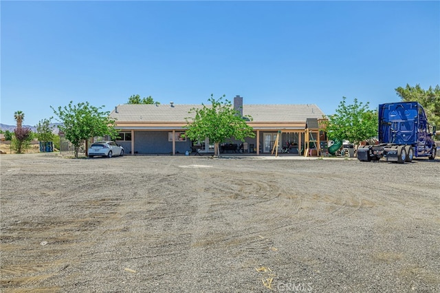 38740 25th St E, Palmdale, CA 93550 - view of front facade with a chimney, a tile roof, and uncovered parking