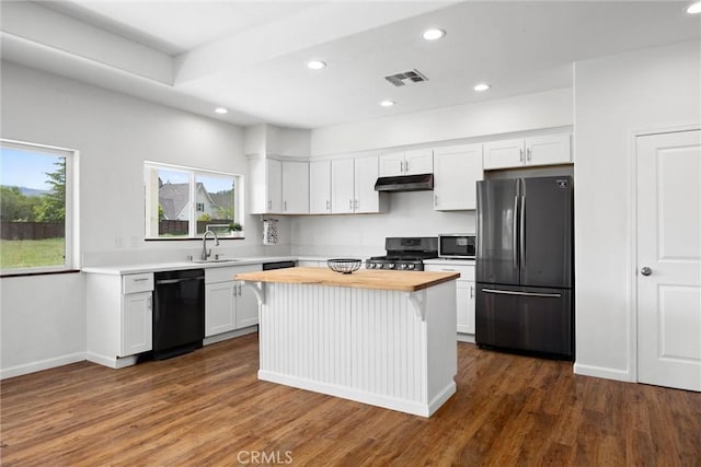 kitchen with black appliances, wooden counters, under cabinet range hood, recessed lighting, and white cabinetry