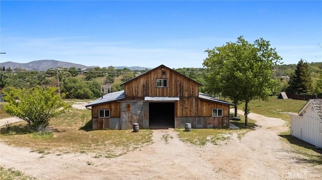 view of barn with driveway and a mountain view