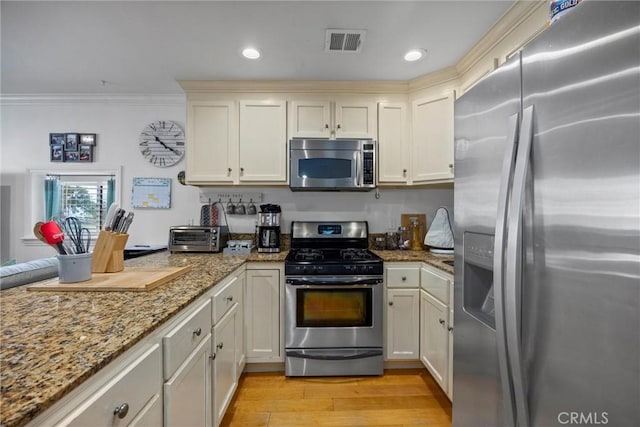 kitchen with stainless steel appliances, light wood-style floors, light stone countertops, ornamental molding, and recessed lighting