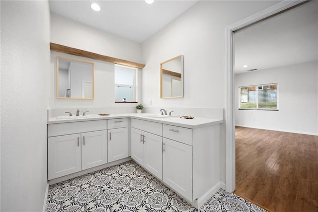 full bathroom with healthy amount of natural light, recessed lighting, and double vanity
