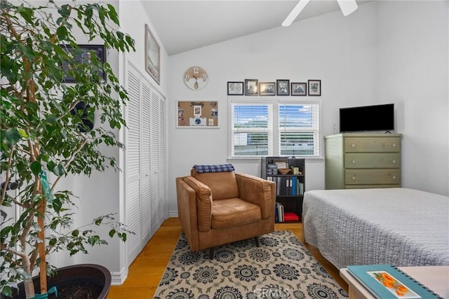 bedroom featuring light wood finished floors, lofted ceiling, a ceiling fan, and baseboards