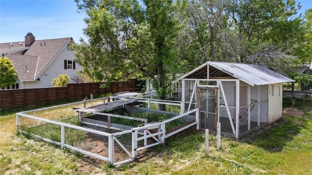 view of poultry coop with fence and a vegetable garden