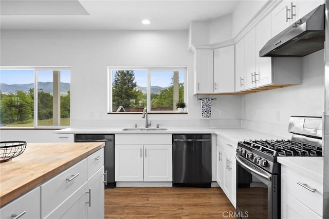 kitchen with stainless steel appliances, a sink, wooden counters, extractor fan, and recessed lighting