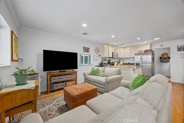 living room featuring light wood-type flooring, crown molding, recessed lighting, and baseboards