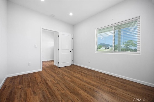 unfurnished room with baseboards, wood finished floors, and recessed lighting
