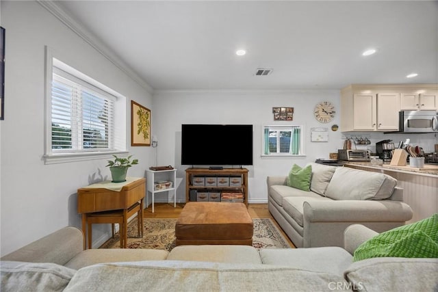 living area featuring light wood-style floors, recessed lighting, and ornamental molding