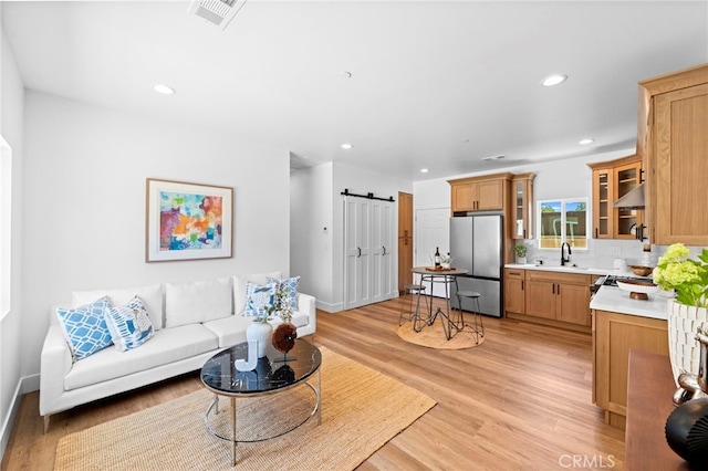 160 S Altadena Dr, Pasadena, CA 91107 - living room featuring a barn door, light wood-style floors, recessed lighting, and baseboards