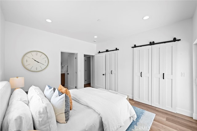 160 S Altadena Dr, Pasadena, CA 91107 - bedroom with a barn door, light wood finished floors, recessed lighting, baseboards, and ensuite bathroom