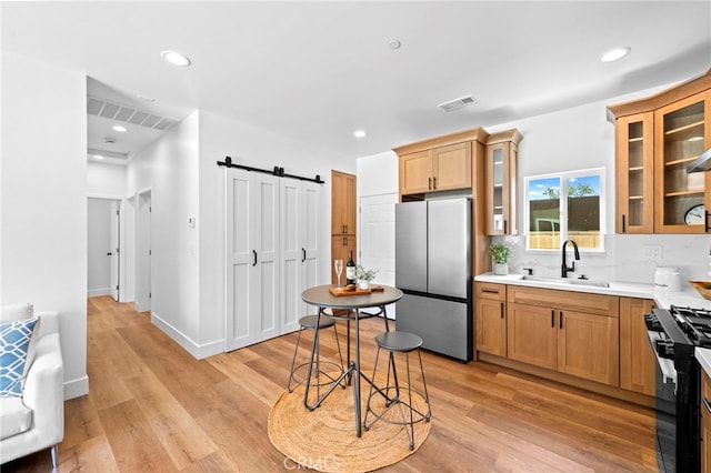 160 S Altadena Dr, Pasadena, CA 91107 - kitchen featuring freestanding refrigerator, a sink, range with gas cooktop, a barn door, and light wood-style flooring