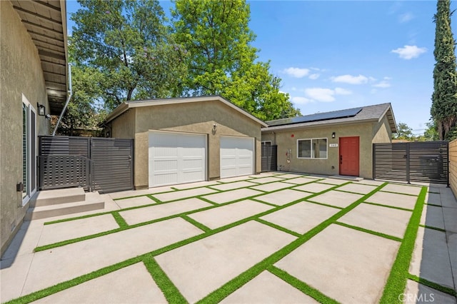 160 S Altadena Dr, Pasadena, CA 91107 - view of front of house featuring stucco siding, a garage, an outbuilding, roof mounted solar panels, and fence