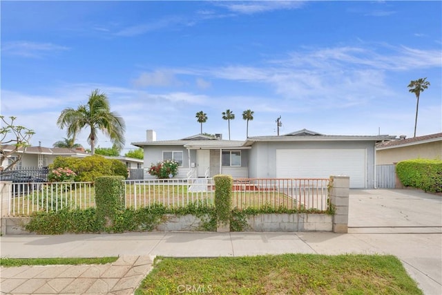 ranch-style house with concrete driveway, a garage, a fenced front yard, and stucco siding