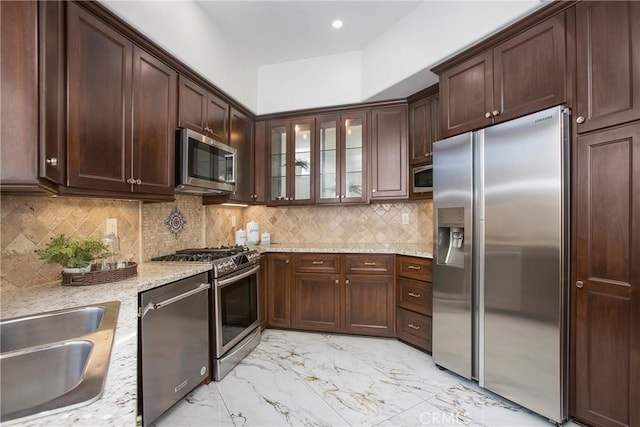 11 Via Pamplona, Rancho Santa Margarita, CA 92688 - kitchen with stainless steel appliances, a sink, light marble finish floors, light stone counters, and dark brown cabinetry