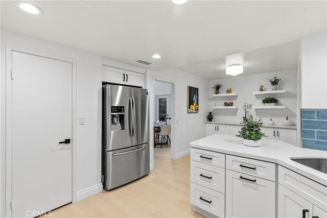 30 Yorktown, Irvine, CA 92620 - kitchen with stainless steel refrigerator with ice dispenser, open shelves, white cabinets, light wood finished floors, and light countertops