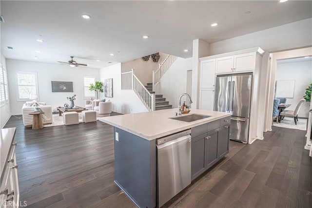 kitchen featuring appliances with stainless steel finishes, a sink, ceiling fan, light countertops, and white cabinetry