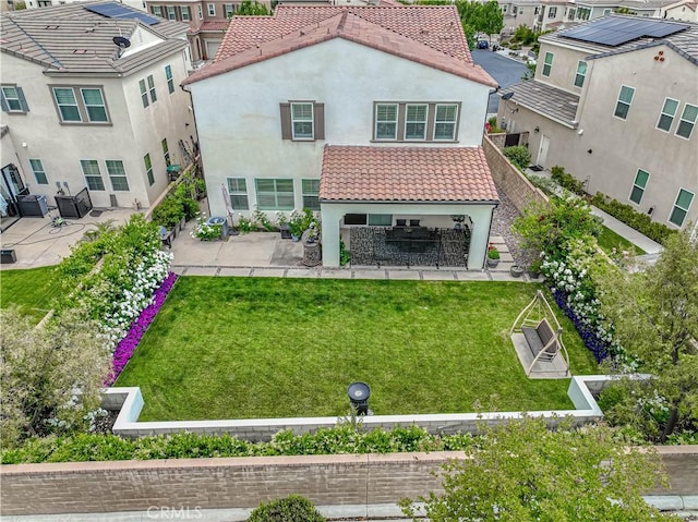 back of property featuring a patio, stucco siding, a tile roof, and a yard