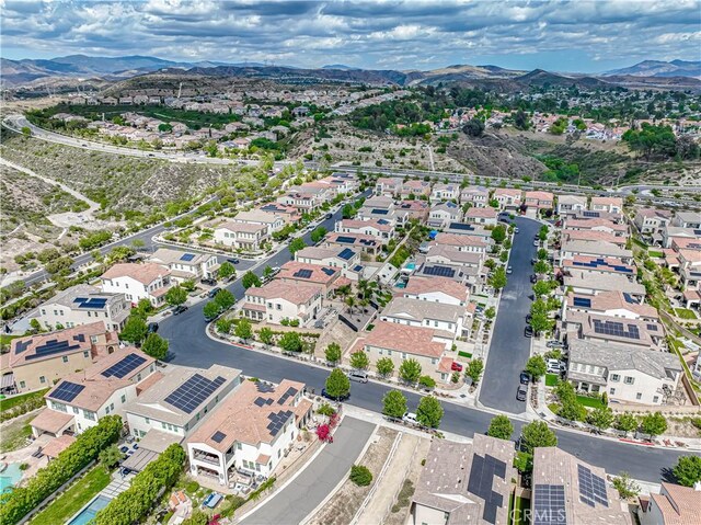 aerial view of property and surrounding area featuring mountains and nearby suburban area