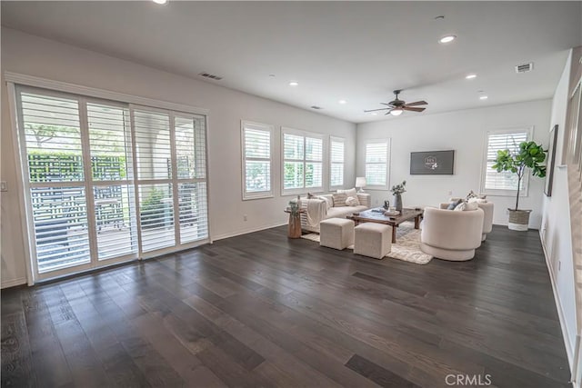 living area with ceiling fan, healthy amount of natural light, dark wood-type flooring, baseboards, and recessed lighting