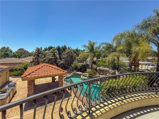 balcony with an in-ground hot tub and view of pool