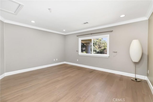 empty room with wood finished floors, baseboards, ornamental molding, and recessed lighting
