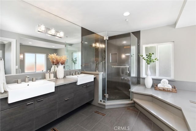 bathroom with a shower stall, double vanity, recessed lighting, and tile patterned floors